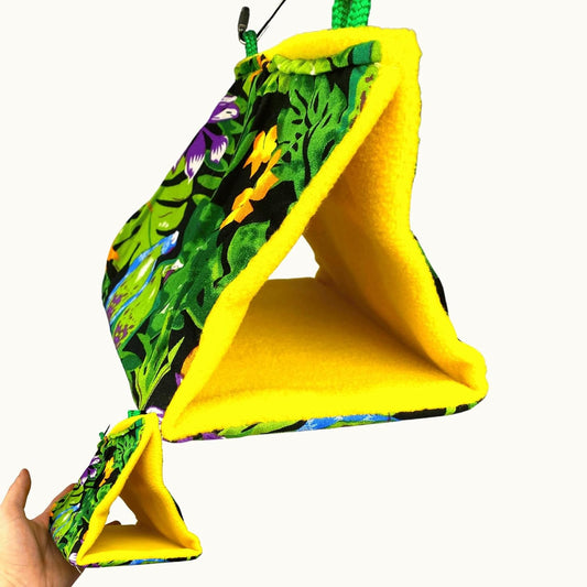 Colorful fabric hammock with a hand holding it against a white background