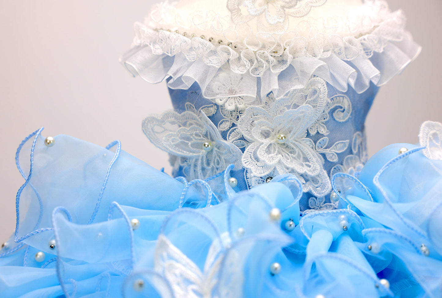Decorative blue and white floral arrangement with ruffled edges on a light gray background
