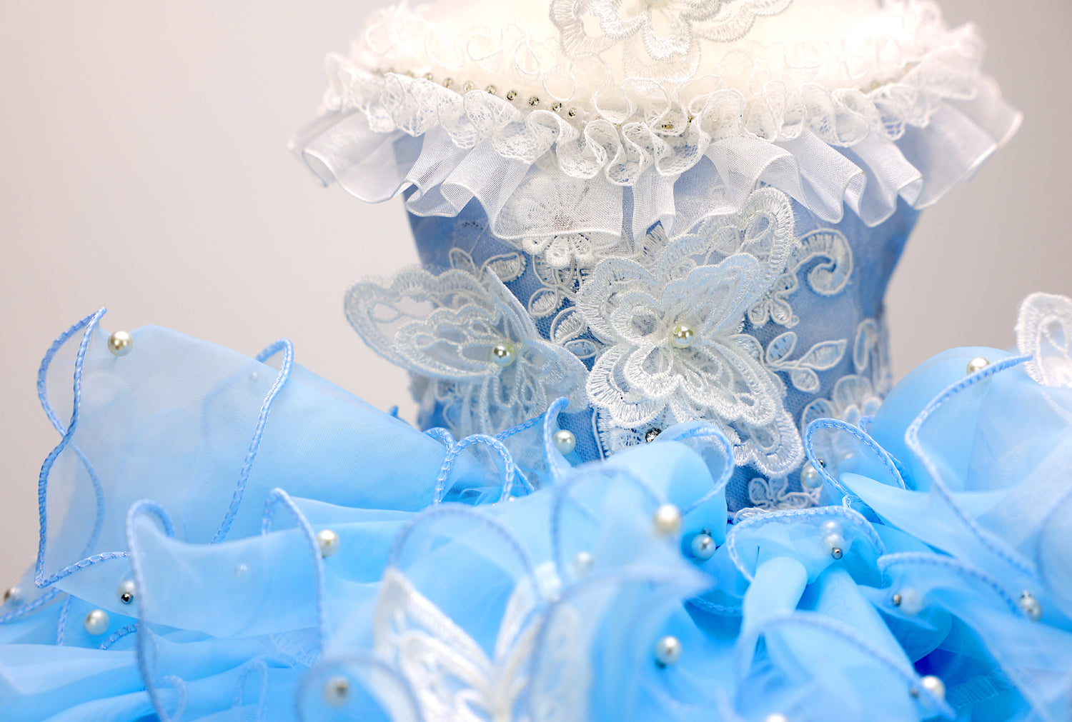 Decorative blue and white floral arrangement with ruffled edges on a light gray background