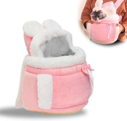 Pink pet bed with white fur trim and bunny ears, featuring a small gray and black cat inside.