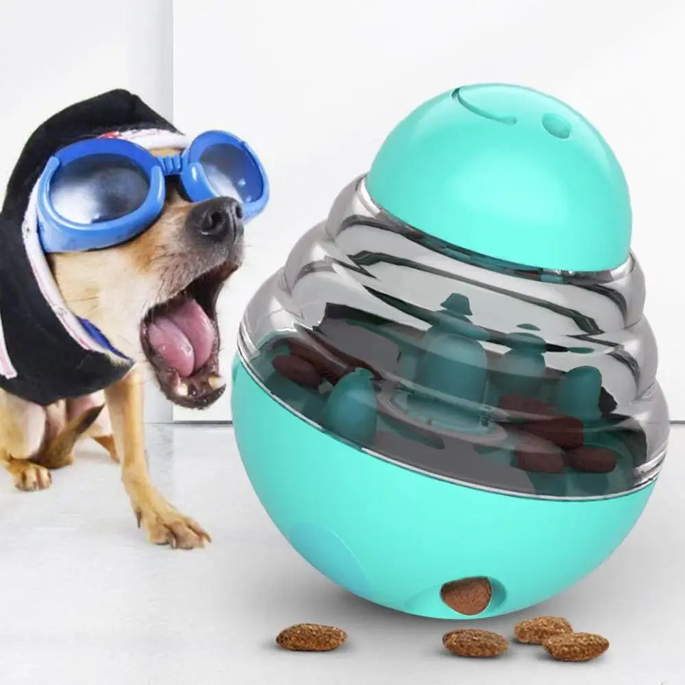 Dog wearing goggles next to a teal and silver ball-shaped pet toy with treats on a white background