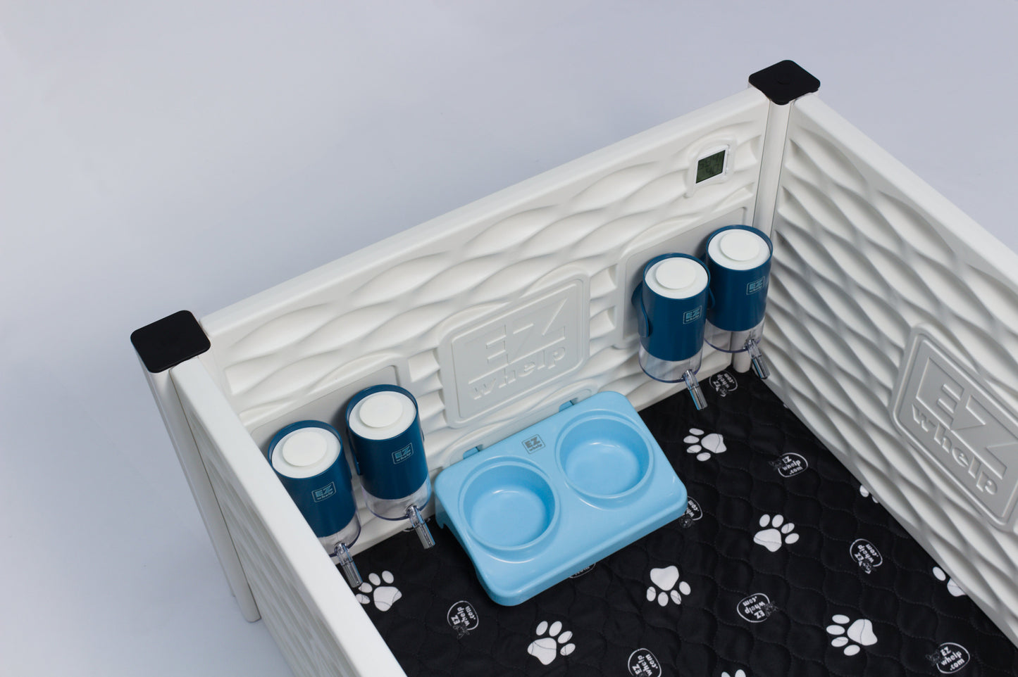 Pet playpen with water bottles and a blue bowl on a gray background