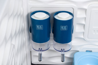 Two blue EZ Whip dessert dispensers inside a refrigerator.
