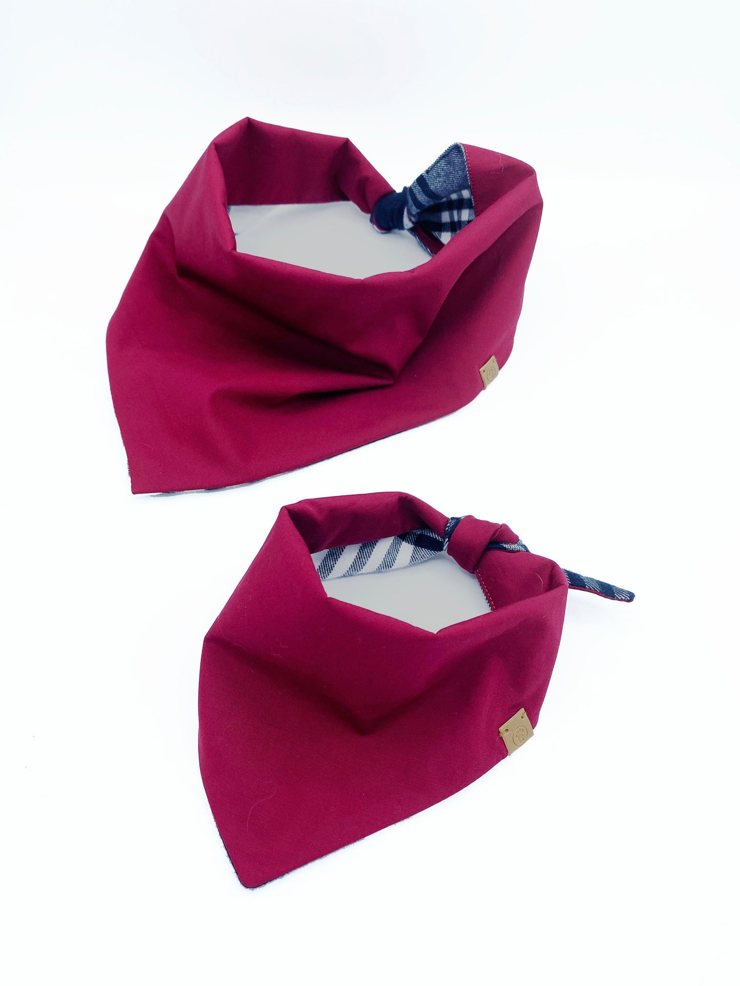 Two magenta bandanas with plaid accents on a white background