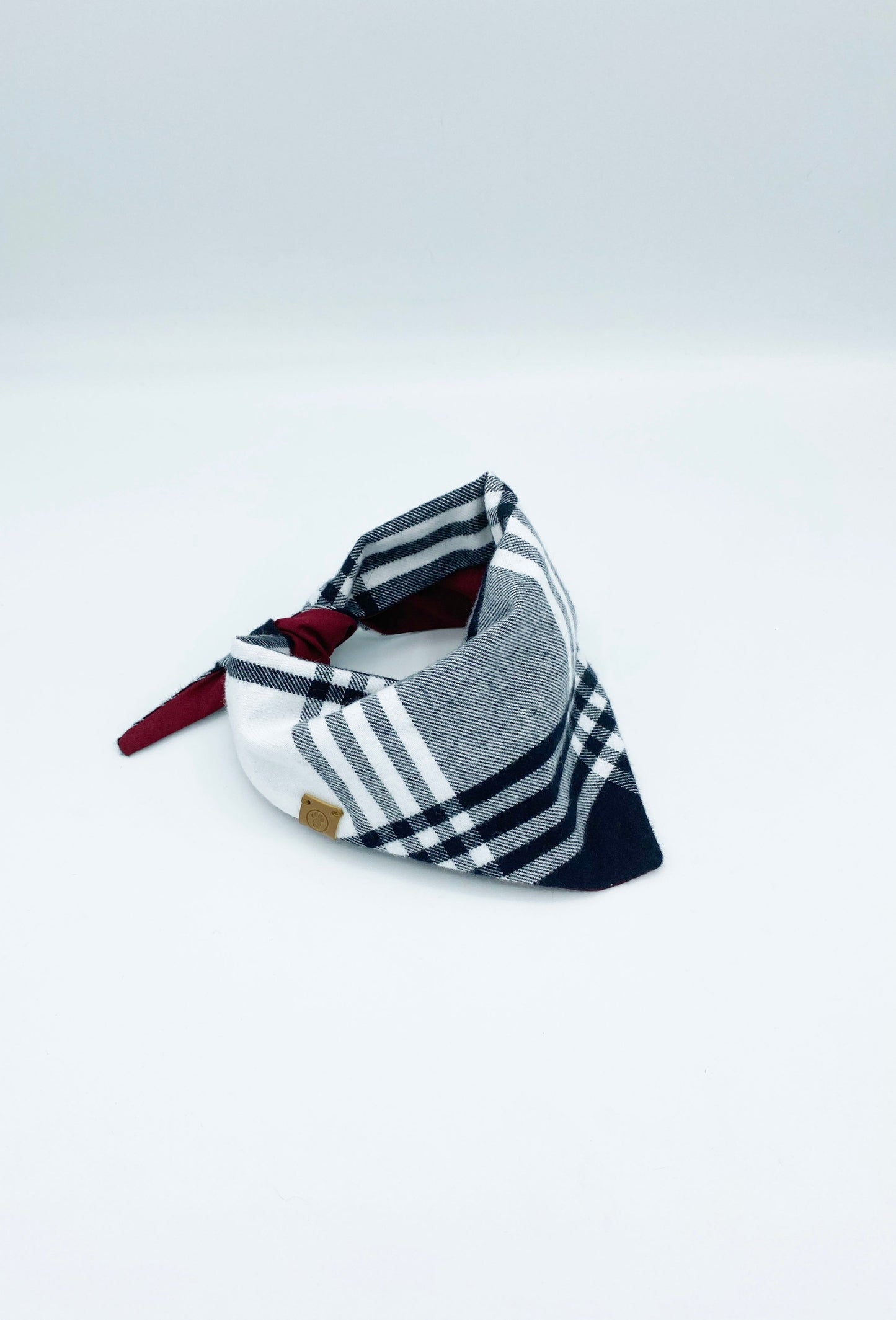 Plaid patterned headband with a red ribbon on a white background