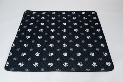 Black quilted pet mat with white paw prints on a white background