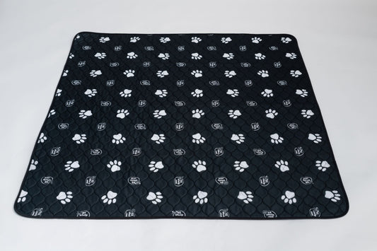 Black quilted pet mat with white paw prints on a white background