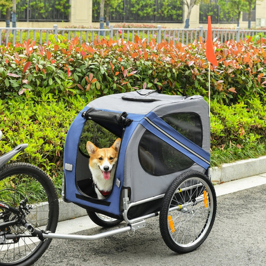 Dog in a bicycle trailer with a green landscape in the background