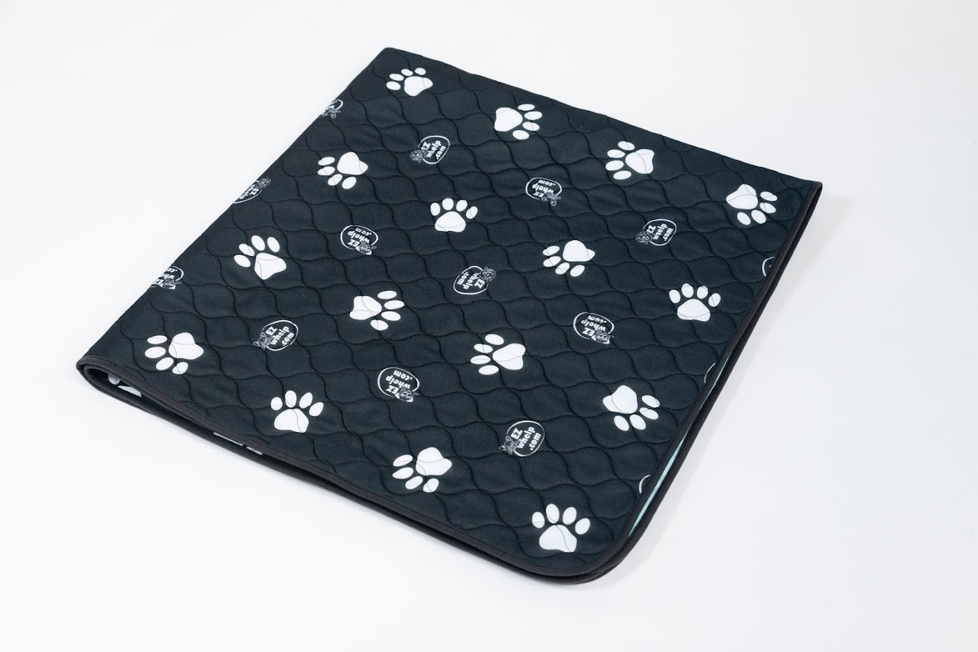 Black pet mat with white paw prints on a white background
