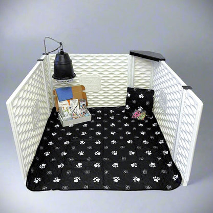 Pet playpen with a black paw print mat inside, on a plain background