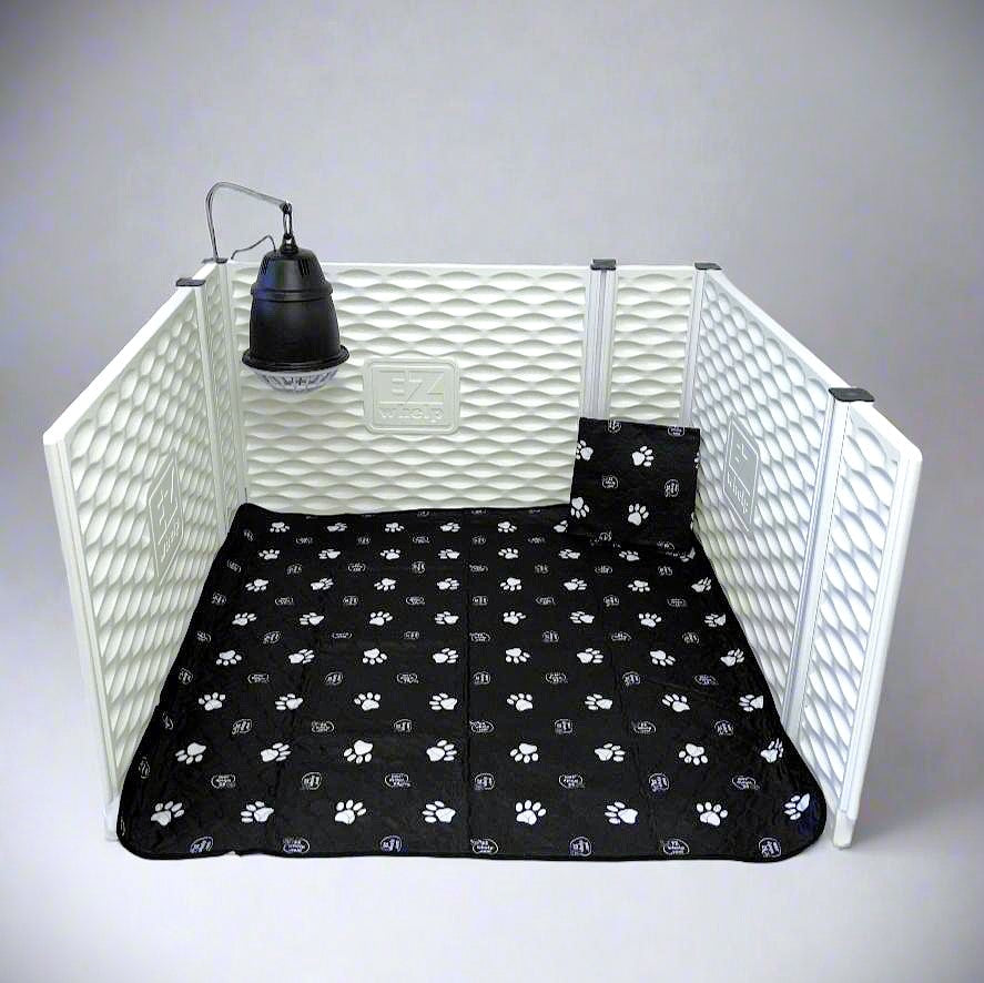 Black paw print mat on a white pet playpen with a lamp hanging above.