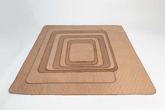 Set of brown quilted placemats of different sizes on a white background