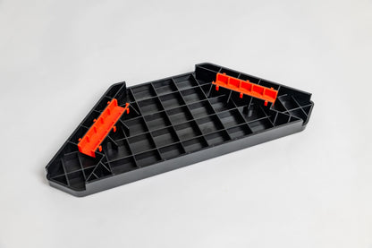 Black plastic tray with red clips on a light gray background
