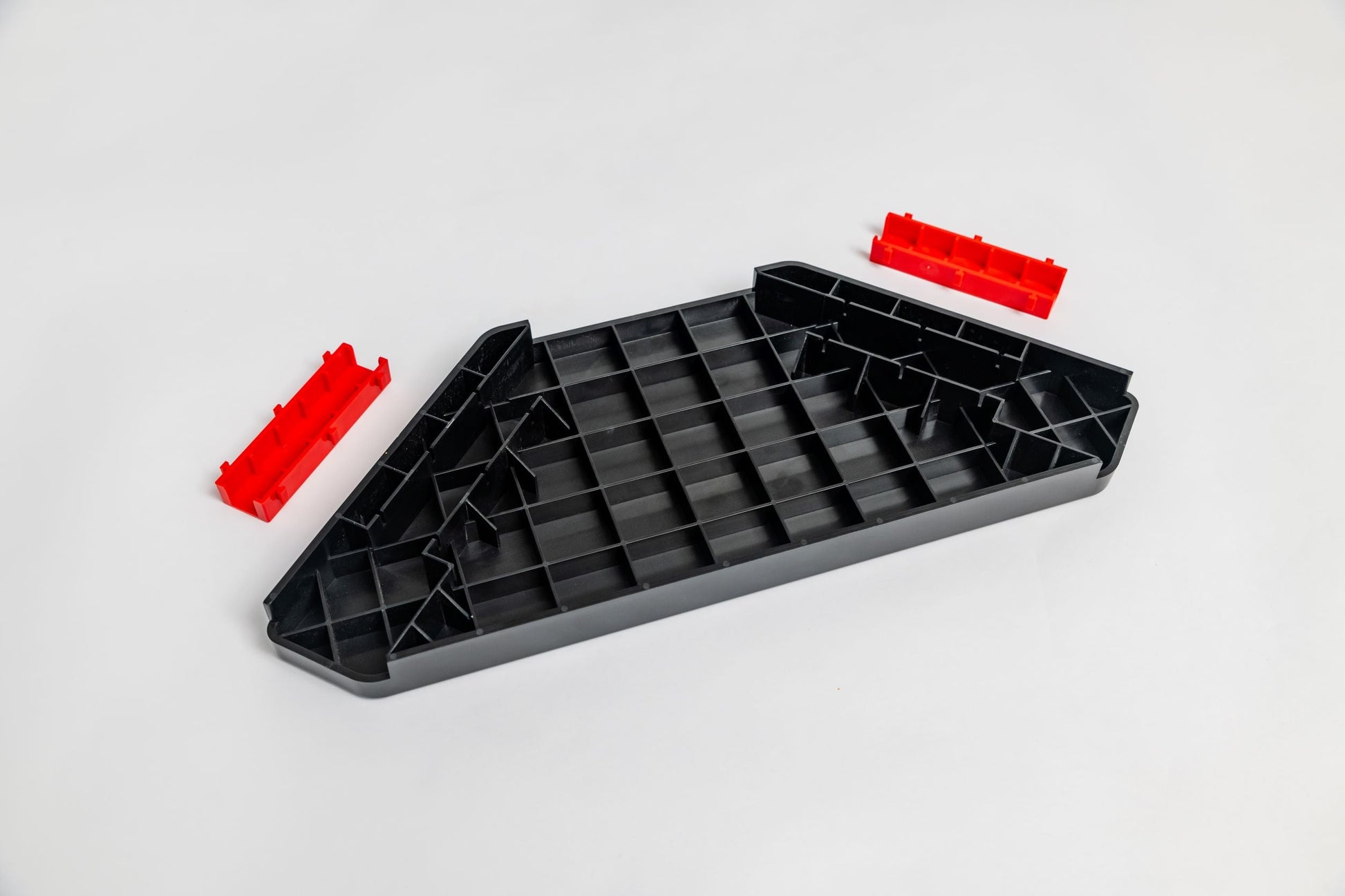 Black plastic tray with red clips on a white background