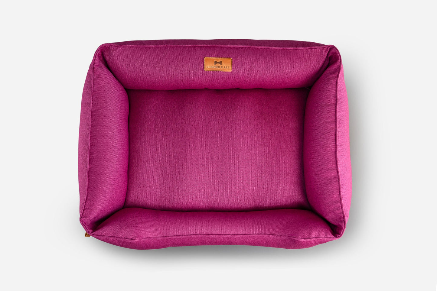 Pink pet bed with a brand label on a white background