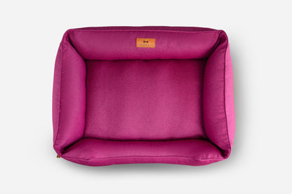 Pink pet bed with a brand label on a white background