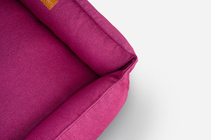 Close-up of a magenta fabric with a visible brand label on a light gray background
