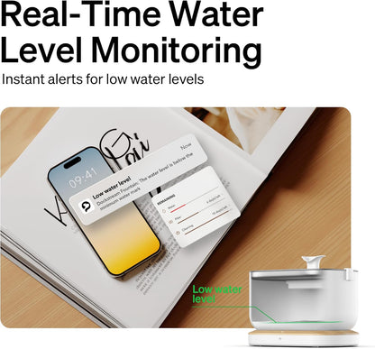 Smart device with water level monitoring app on smartphone screen, placed on a magazine.