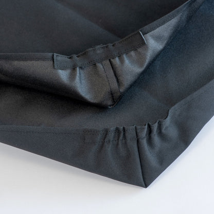 Black fabric with pleated detailing on a white background