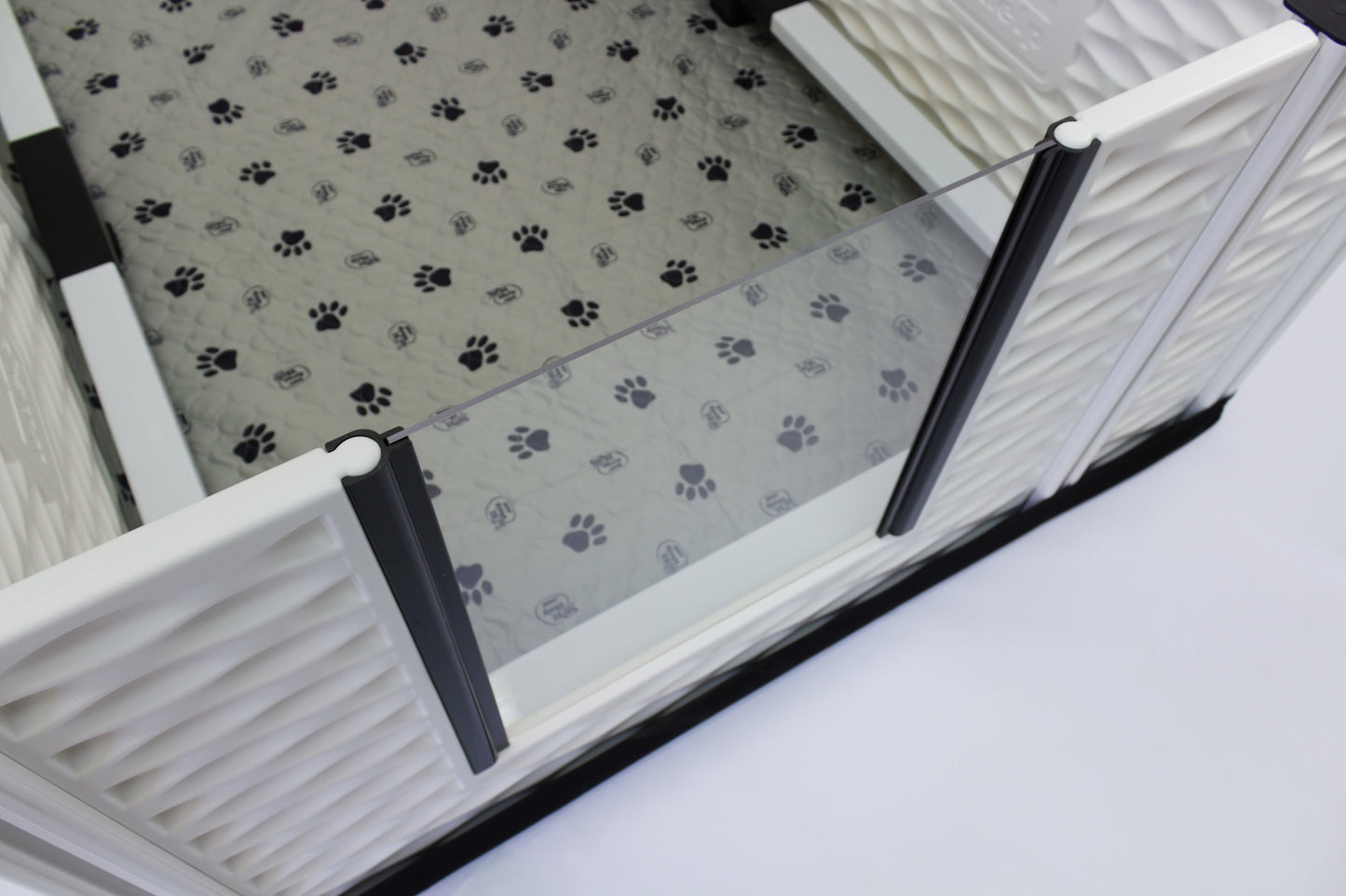 Pet gate with transparent panel on a paw print mat