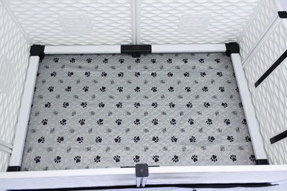 Pet crate with a gray mat featuring black paw prints inside