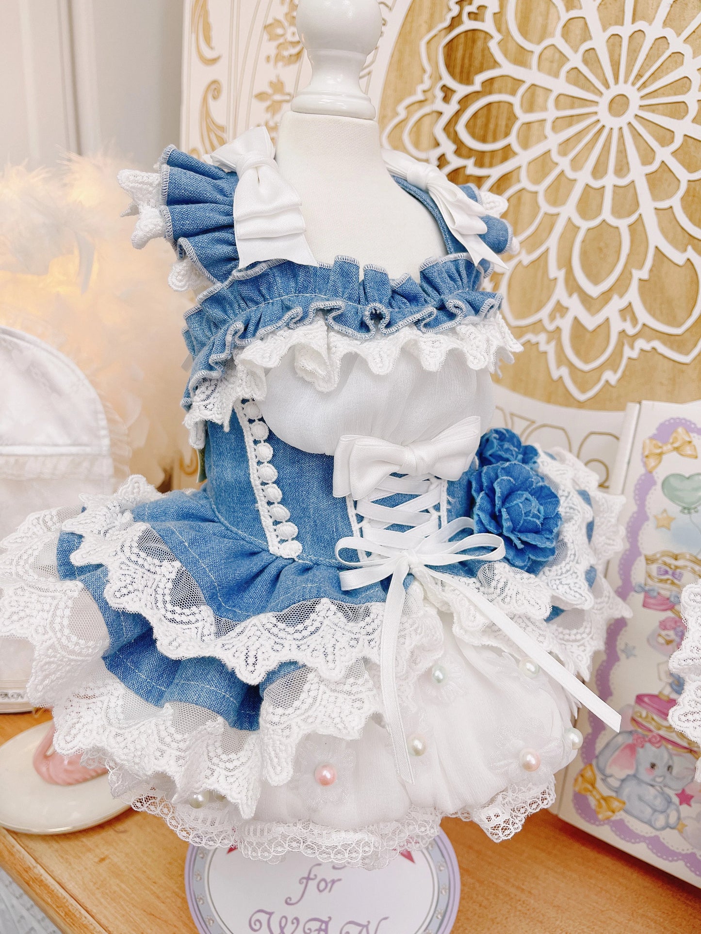 Detailed doll with blue and white dress on a decorative stand