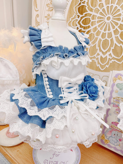 Detailed doll with blue and white dress on a decorative stand