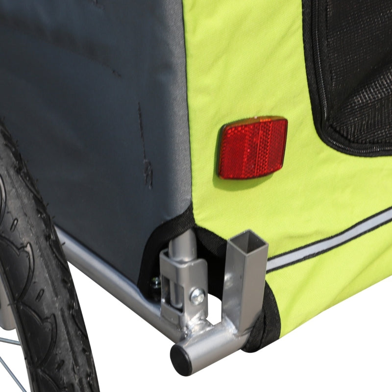 Close-up of a bike trailer with a red reflector and black and yellow design.