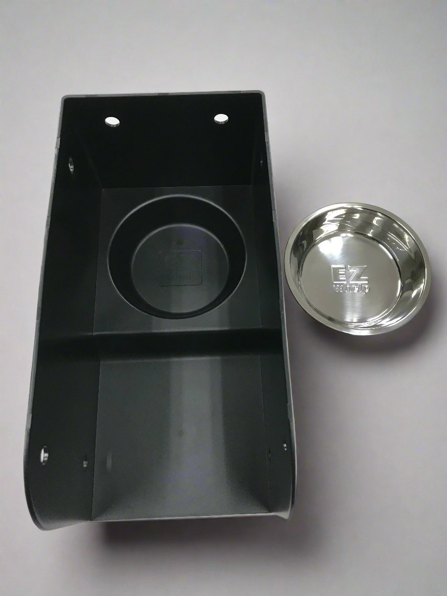 Black plastic component with a silver metal disc on a gray background