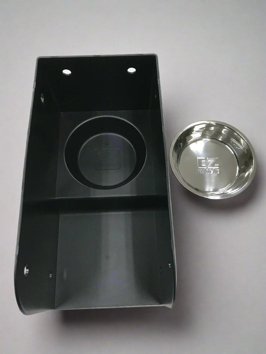 Black plastic component with a silver metal disc on a gray background