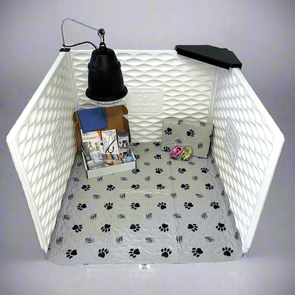 Pet playpen with paw print bedding, toys, and a lamp on a white background