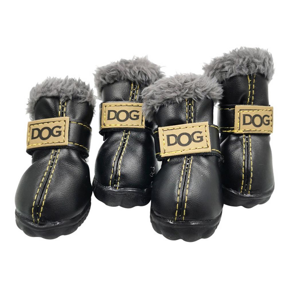 Four black dog boots with gray fur lining and gold accents on a white background
