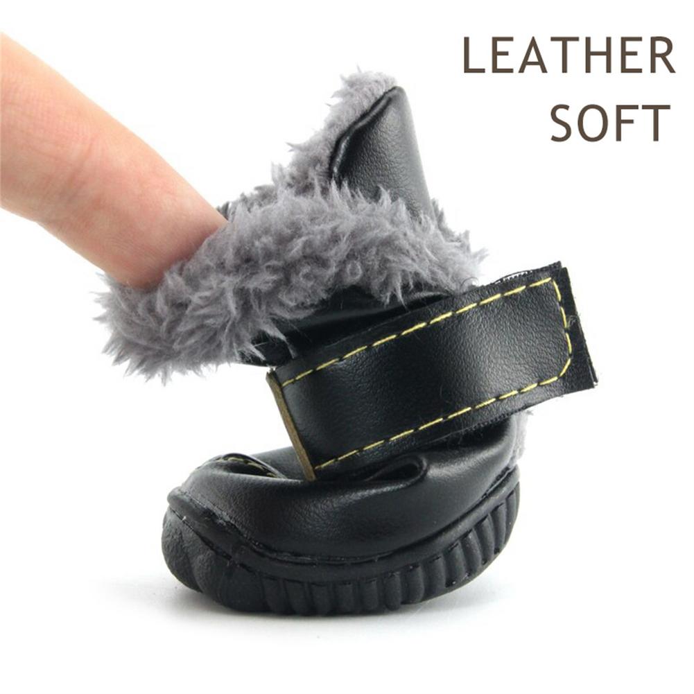 Black leather dog boot with gray fur on a white background