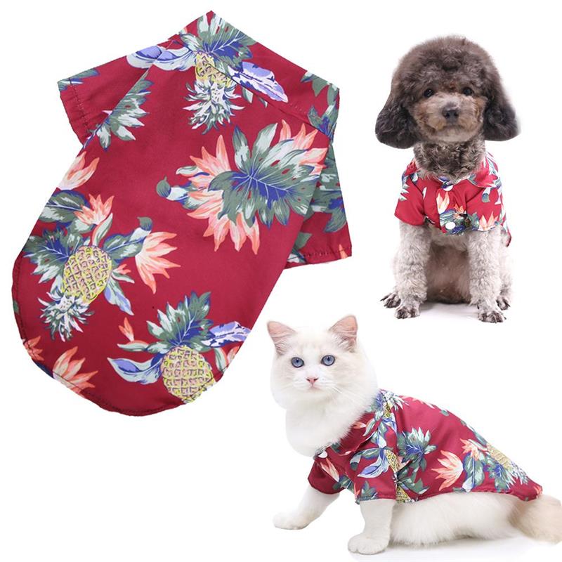 Red floral shirt with pineapple design on a white background, featuring a dog and cat wearing the shirt.