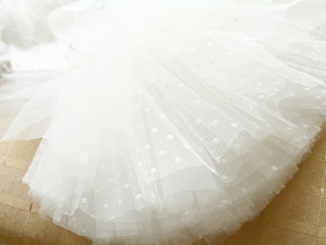 Close-up of a white tulle skirt on a wooden surface