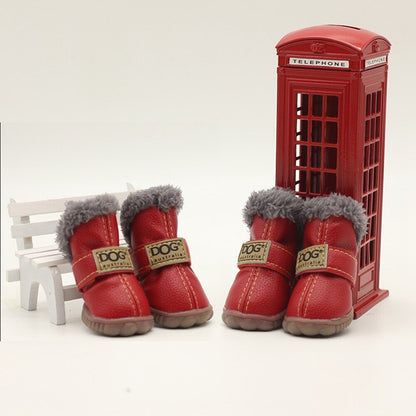 Red dog boots with gray fur lining in front of a miniature red telephone box on a white background