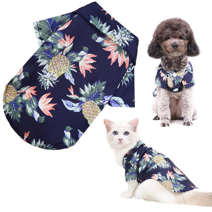 Navy blue pet shirt with pineapple and flower pattern worn by a dog and cat on a white background