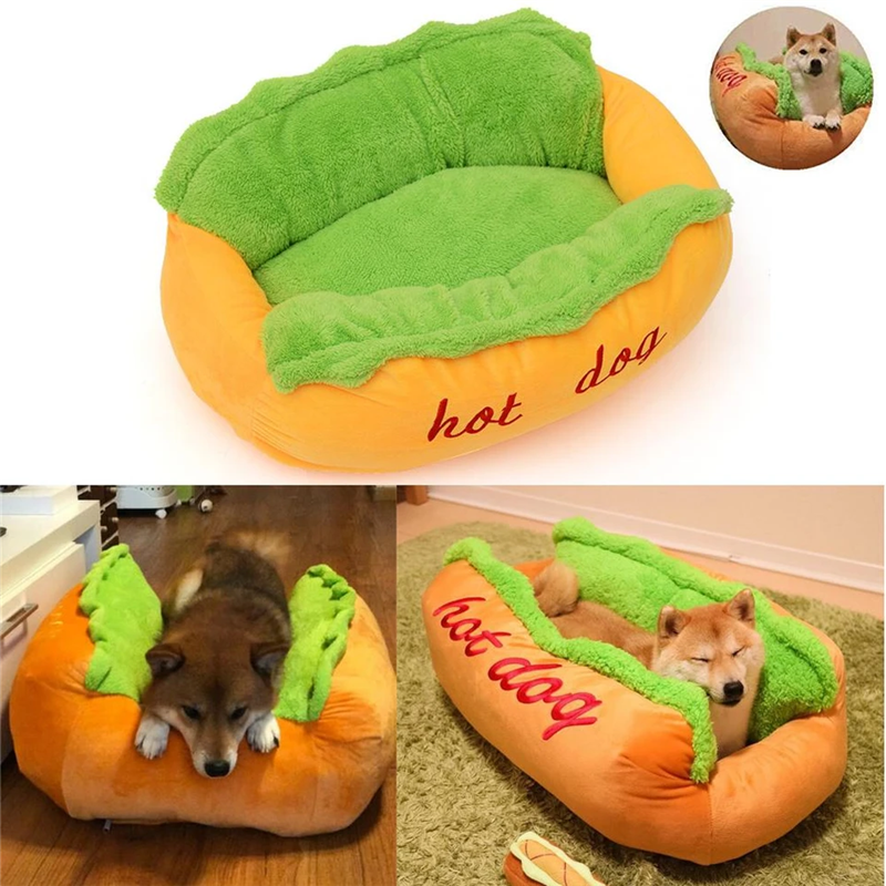 Hot dog-shaped pet bed with plush green top and orange bottom, featuring the word 'hot dog' on a white background.