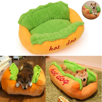 Hot dog-shaped pet bed with plush green top and orange bottom, featuring the word 'hot dog' on a white background.
