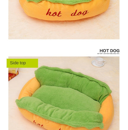 Hot dog-shaped pet bed with green blanket on a beige surface