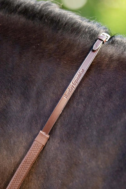 Brown leather bridle strap on a horse's head with 'Hollie Equestrian' branding.