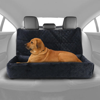Dog sitting on a black quilted car bench seat cover in a vehicle.