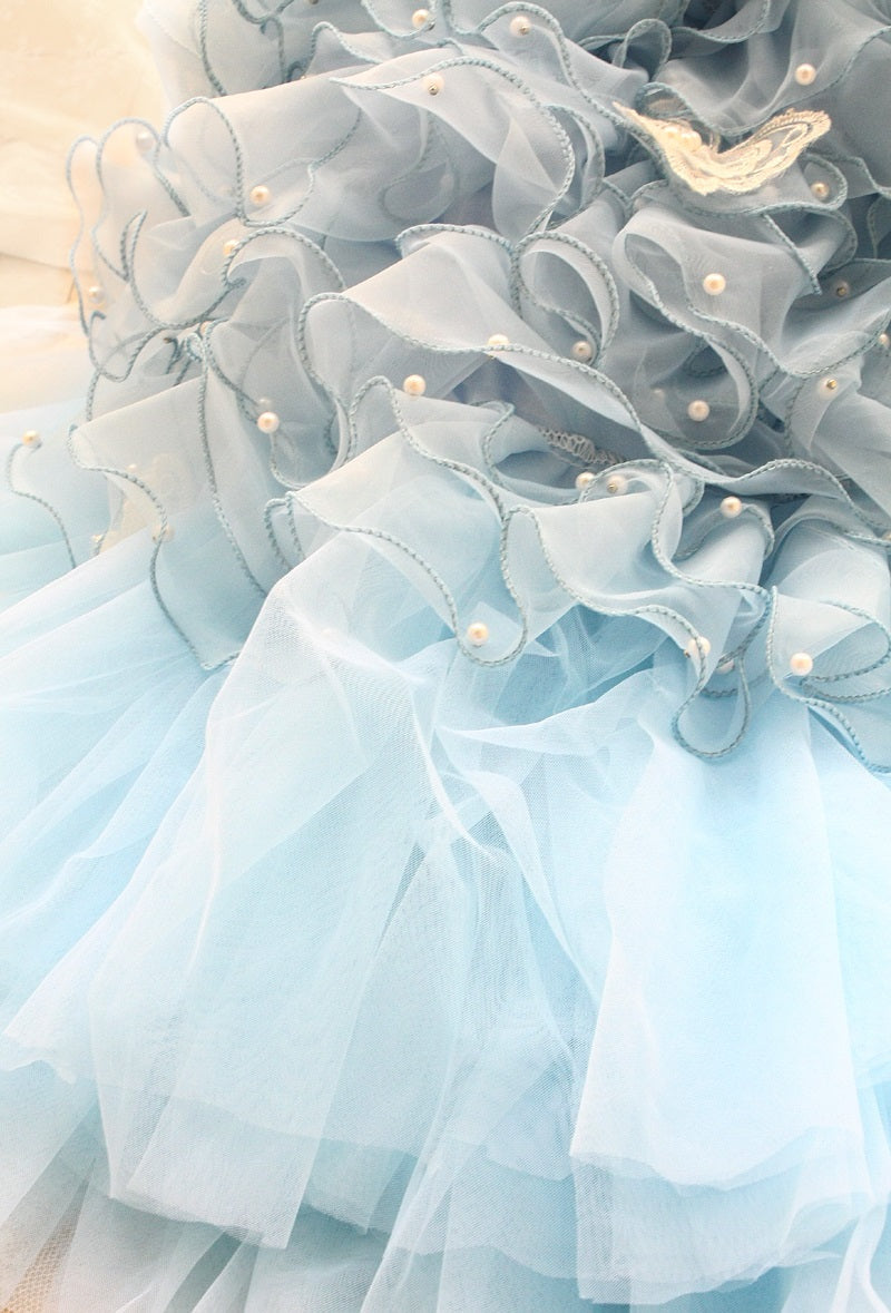 Close-up of a light blue ruffled fabric with pearls on a soft background