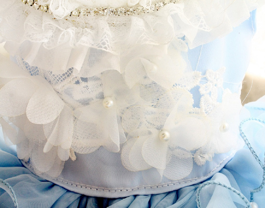 Close-up of a decorative headband with white flowers and pearls on a blue background