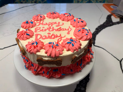 Birthday cake with pink frosting and 'Happy Birthday Daisy' text on a white plate.