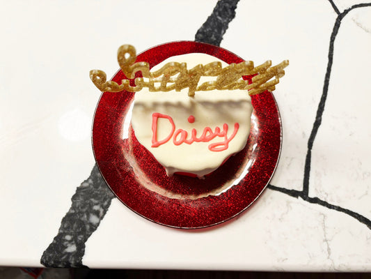 Decorative plate with a heart-shaped item and 'Daisy' text on a white background