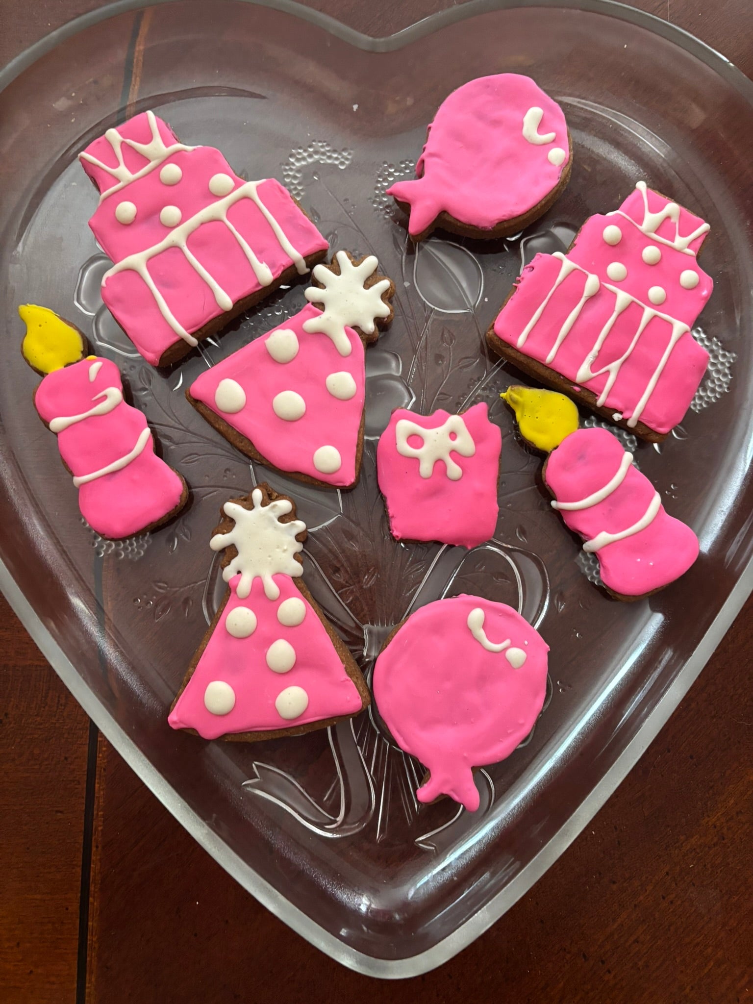 Decorative cookies shaped like baby items on a heart-shaped cookie cutter.