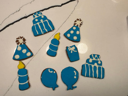 Collection of blue birthday-themed cookies on a white surface