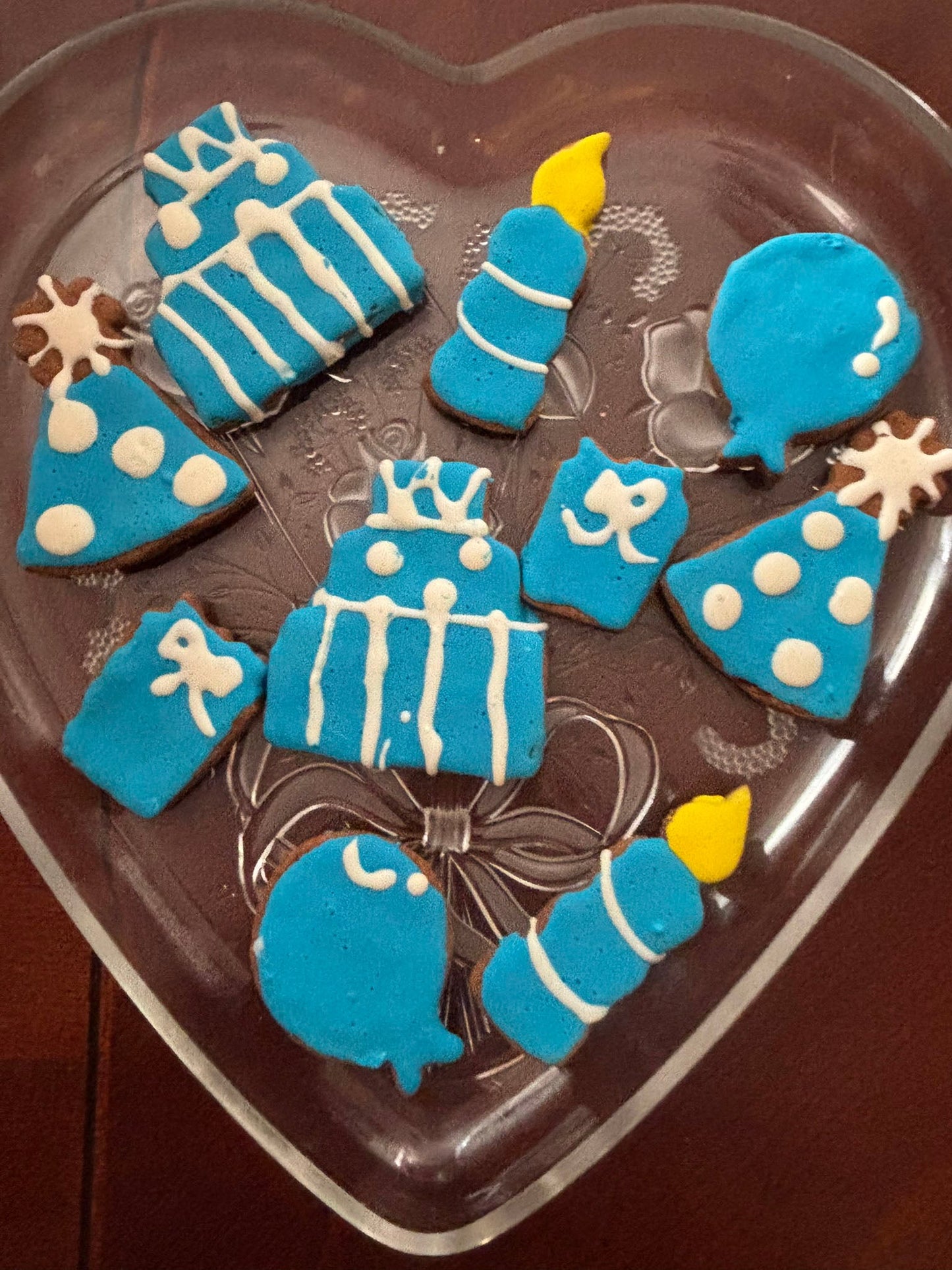 Decorative cookies shaped like birthday items on a heart-shaped tray.