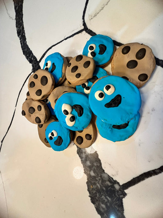 Cookie monster-themed necklace with blue and brown cookie designs on a marble surface.